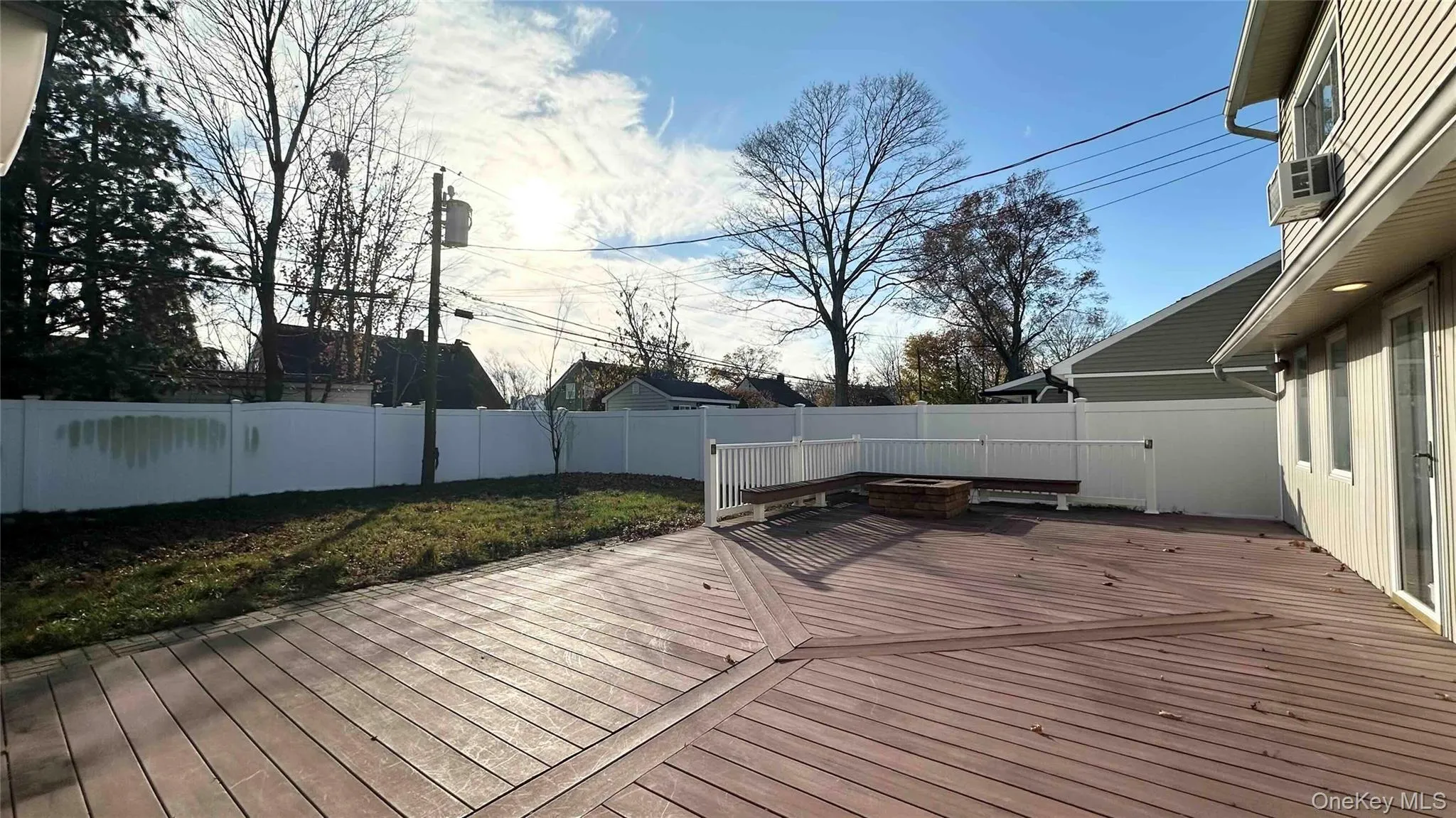 Wooden deck featuring a fire pit and a fenced backyard Wooden deck featuring a fire pit and a fenced backyard