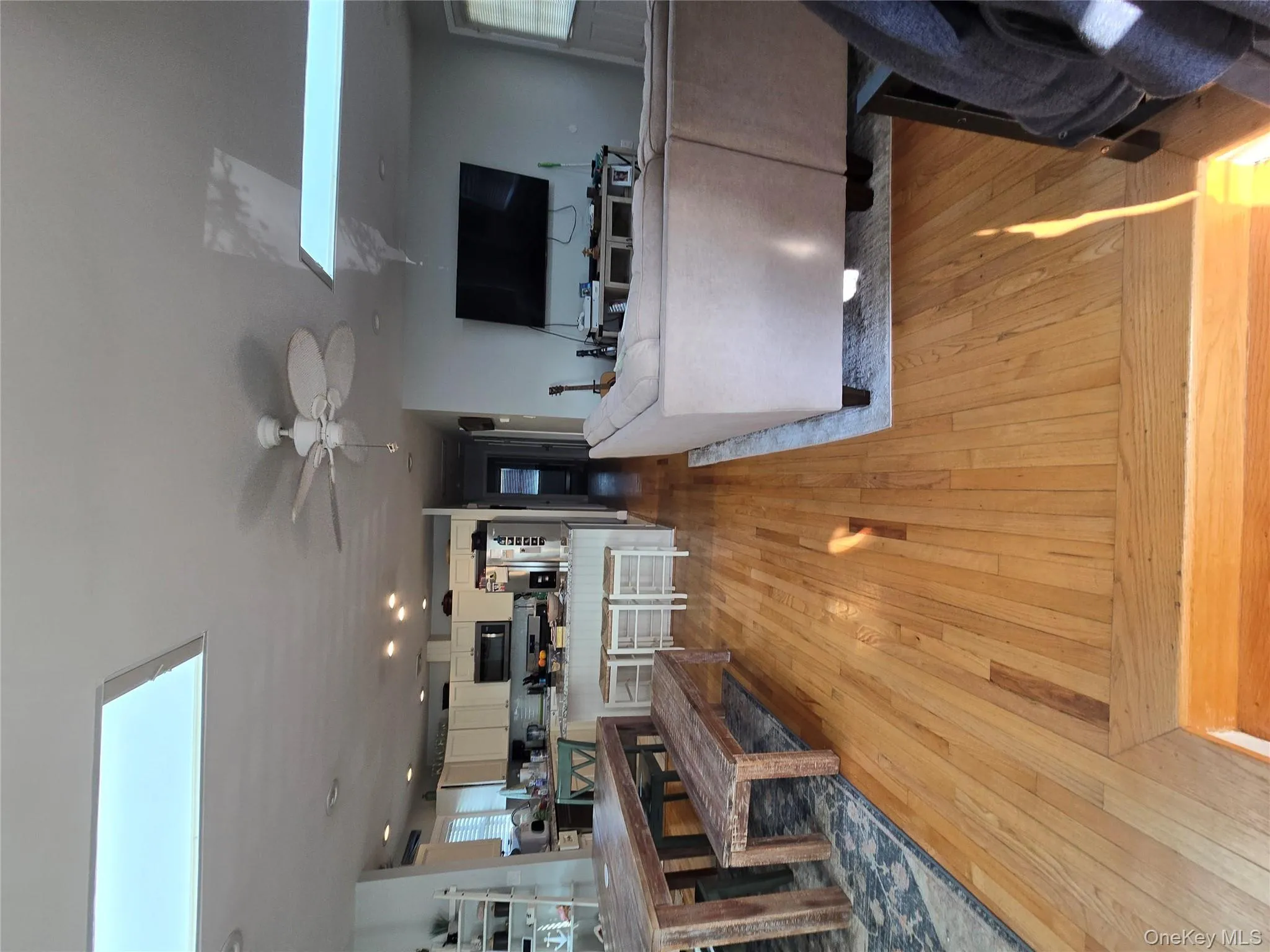 Living area featuring a skylight, light wood-style floors, recessed lighting, and a ceiling fan Living area featuring a skylight, light wood-style floors, recessed lighting, and a ceiling fan