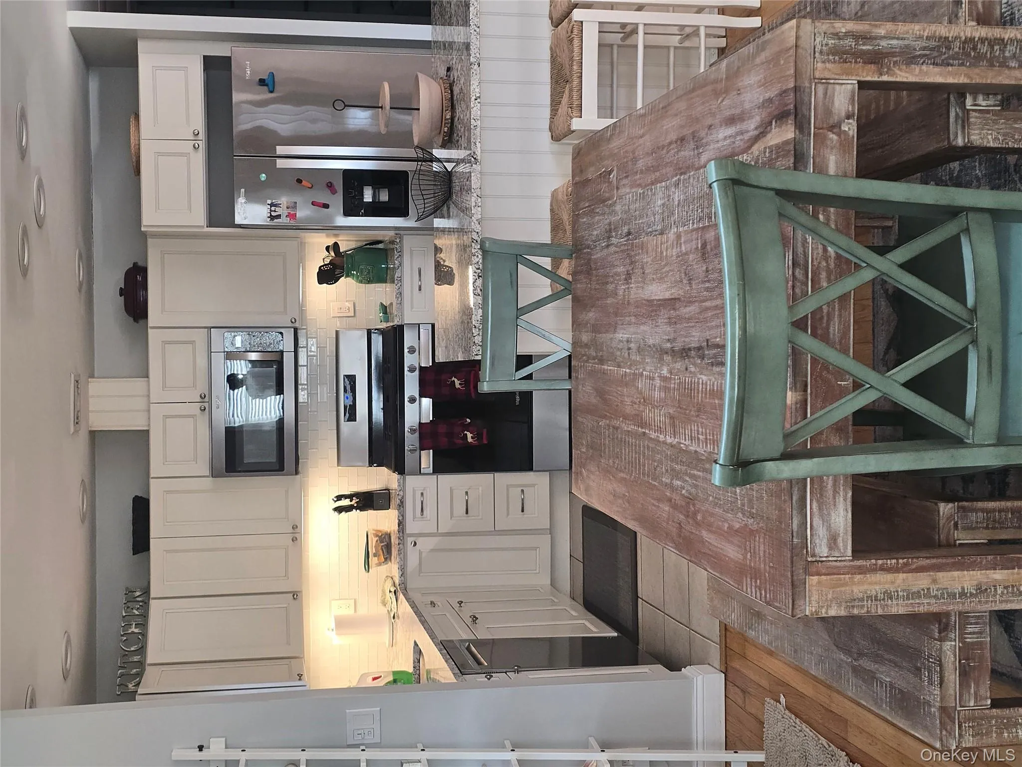 Kitchen with light stone countertops, appliances with stainless steel finishes, white cabinets, decorative backsplash, and dark wood finished floors Kitchen with light stone countertops, appliances with stainless steel finishes, white cabinets, decorative backsplash, and dark wood finished floors