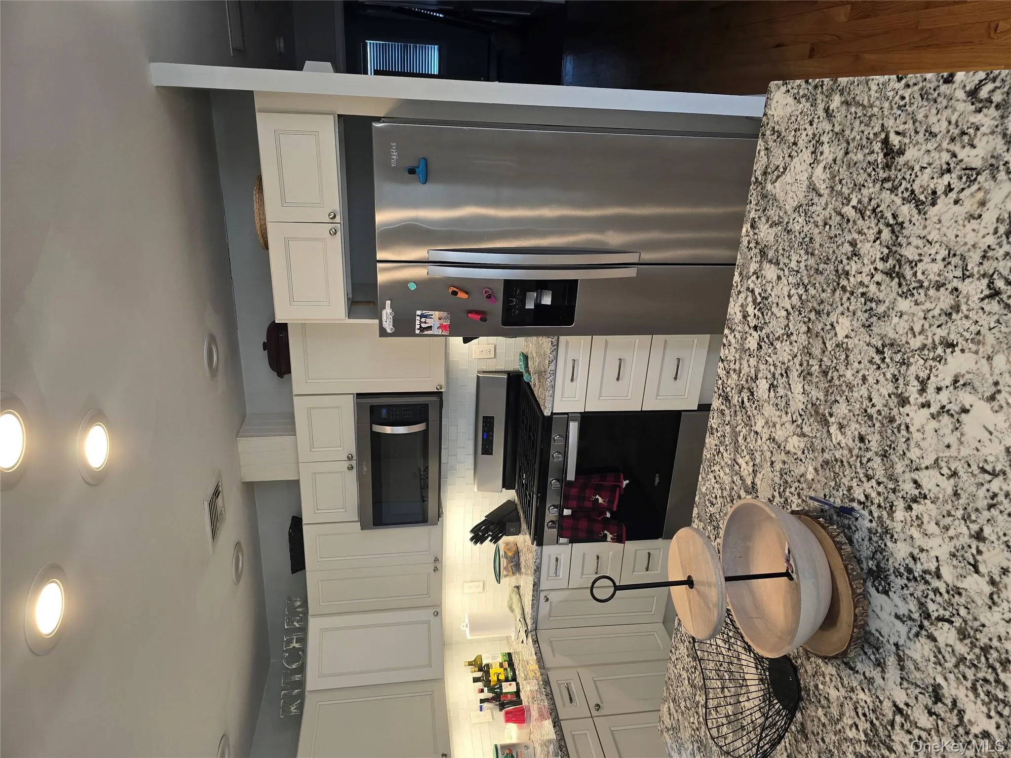 Kitchen with stainless steel appliances, light stone countertops, white cabinetry, recessed lighting, and backsplash Kitchen with stainless steel appliances, light stone countertops, white cabinetry, recessed lighting, and backsplash