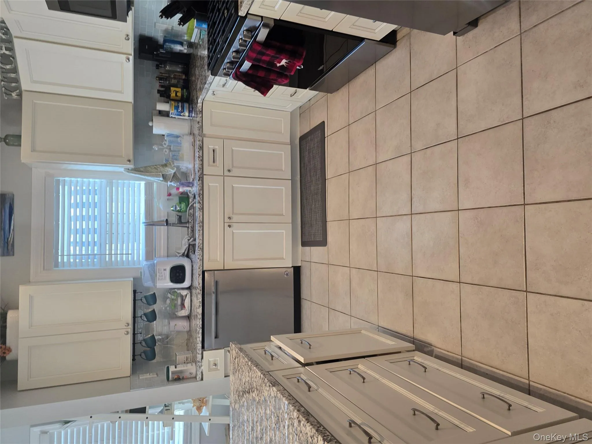 Kitchen featuring stove, dishwasher, decorative backsplash, and light tile patterned floors Kitchen featuring stove, dishwasher, decorative backsplash, and light tile patterned floors