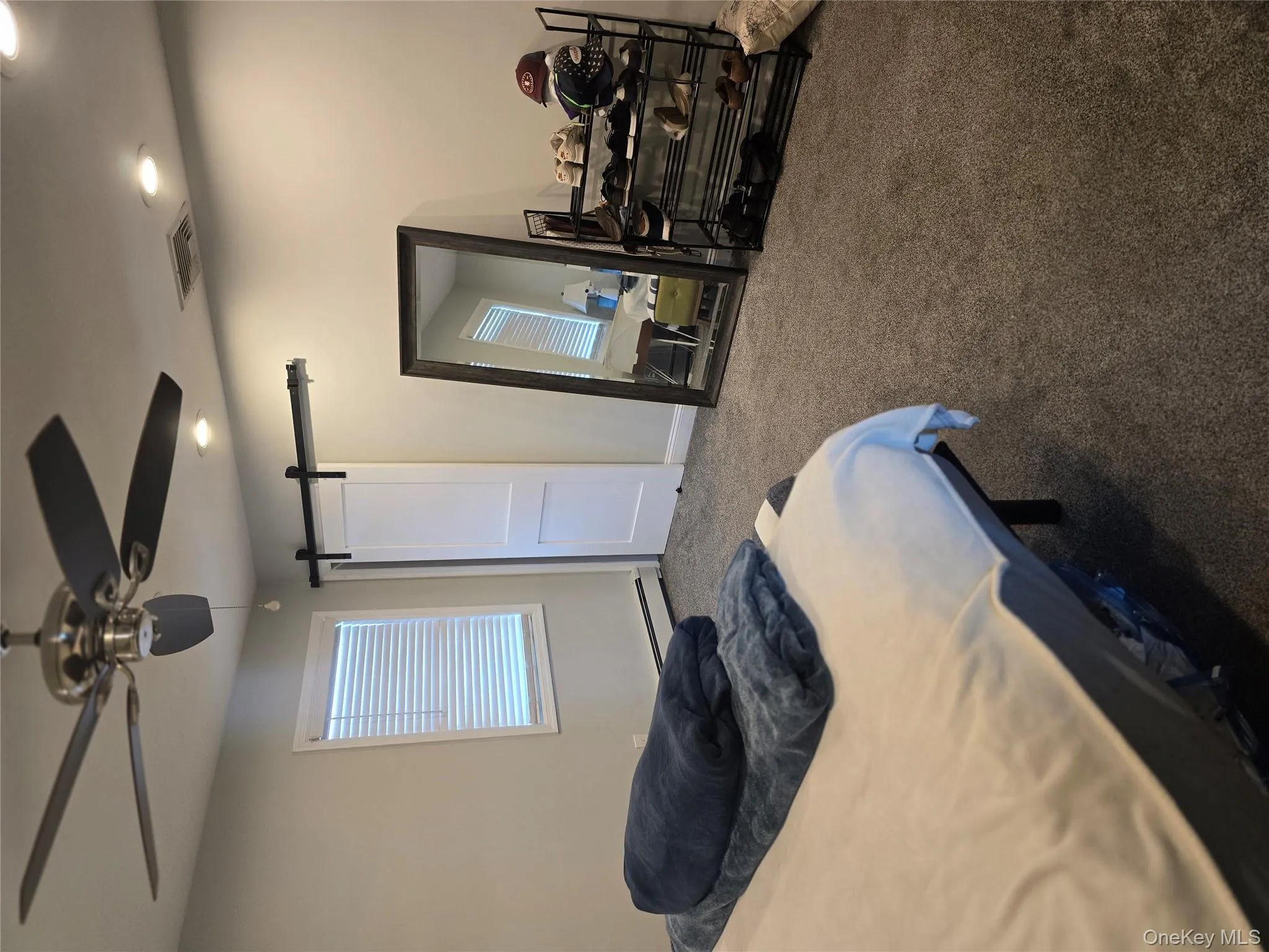 Carpeted bedroom featuring a barn door, ceiling fan, a baseboard heating unit, and recessed lighting Carpeted bedroom featuring a barn door, ceiling fan, a baseboard heating unit, and recessed lighting