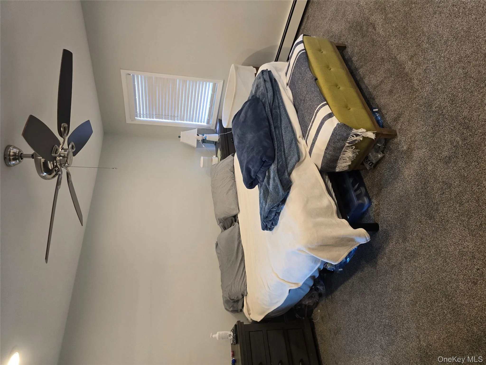 Carpeted bedroom featuring a baseboard heating unit and a ceiling fan Carpeted bedroom featuring a baseboard heating unit and a ceiling fan