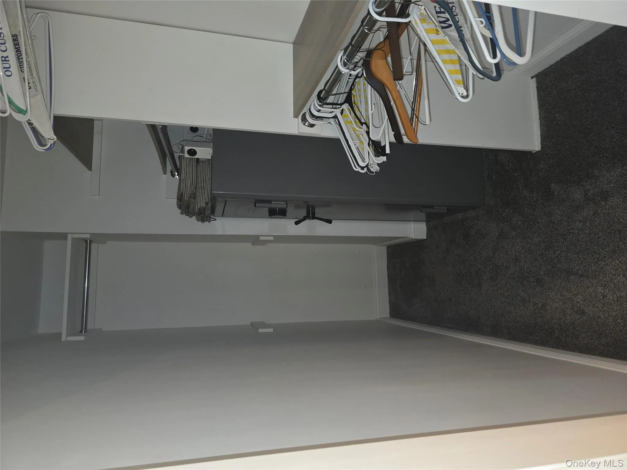 Walk in closet featuring dark colored carpet Walk in closet featuring dark colored carpet