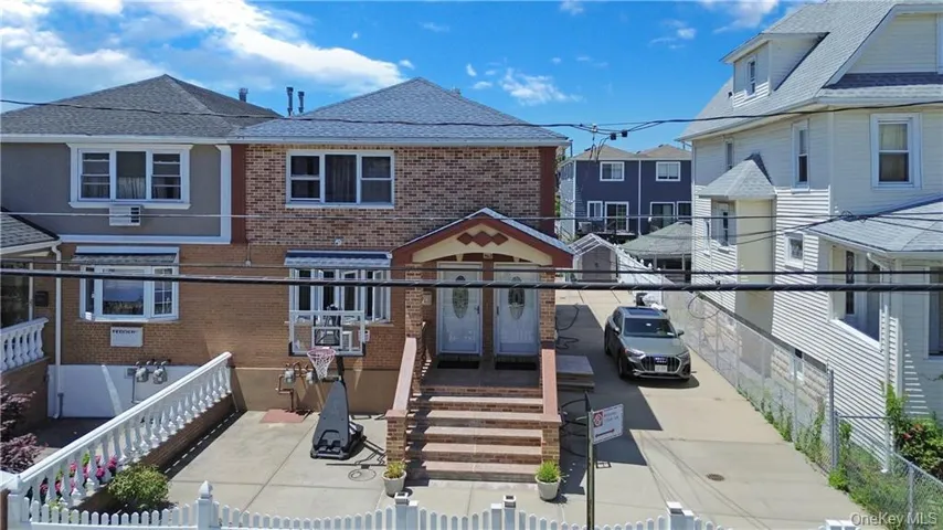 View of front of house featuring brick siding, a residential view, and roof with shingles