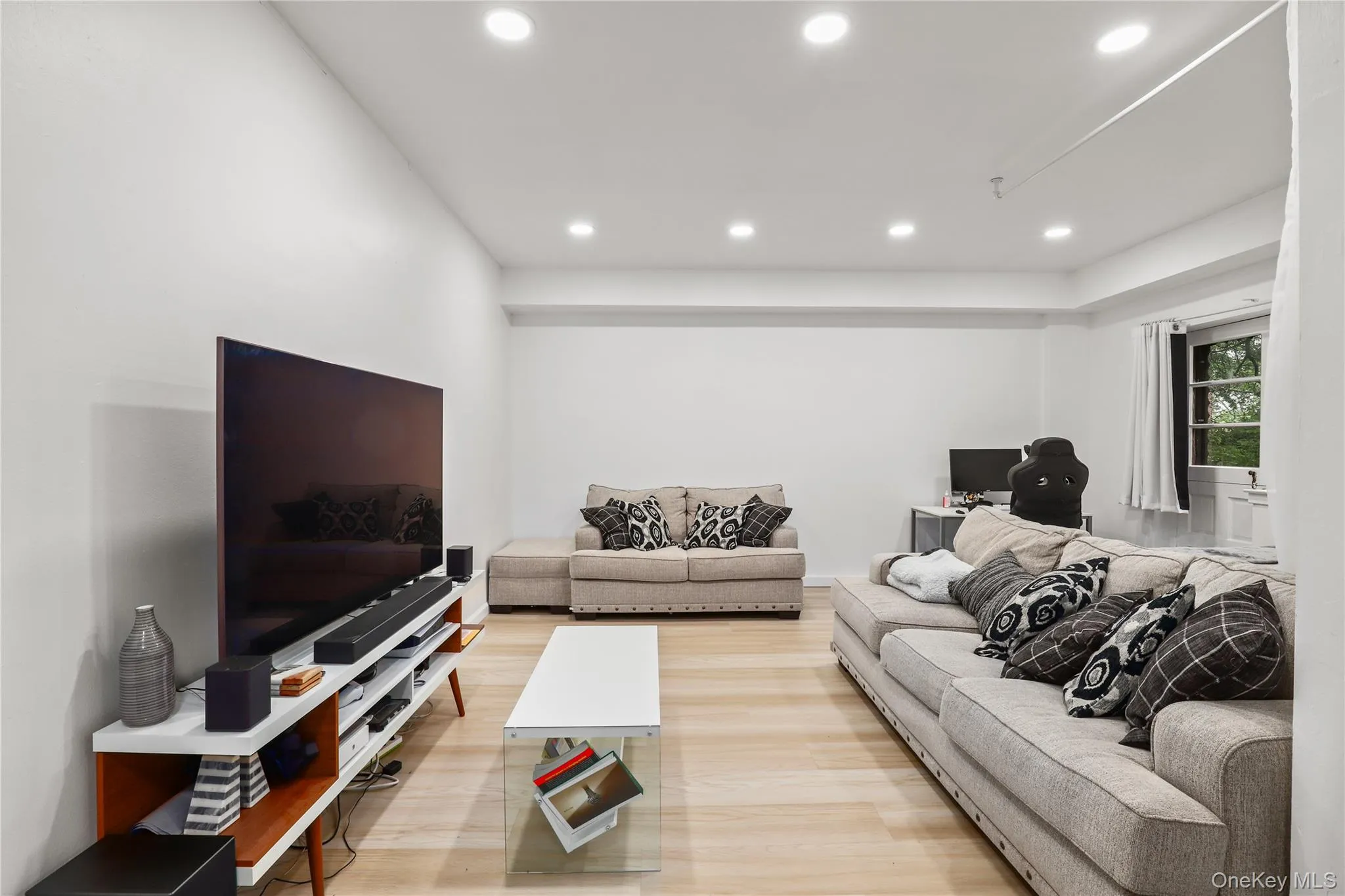 Living area with light wood-type flooring and recessed lighting Living area with light wood-type flooring and recessed lighting