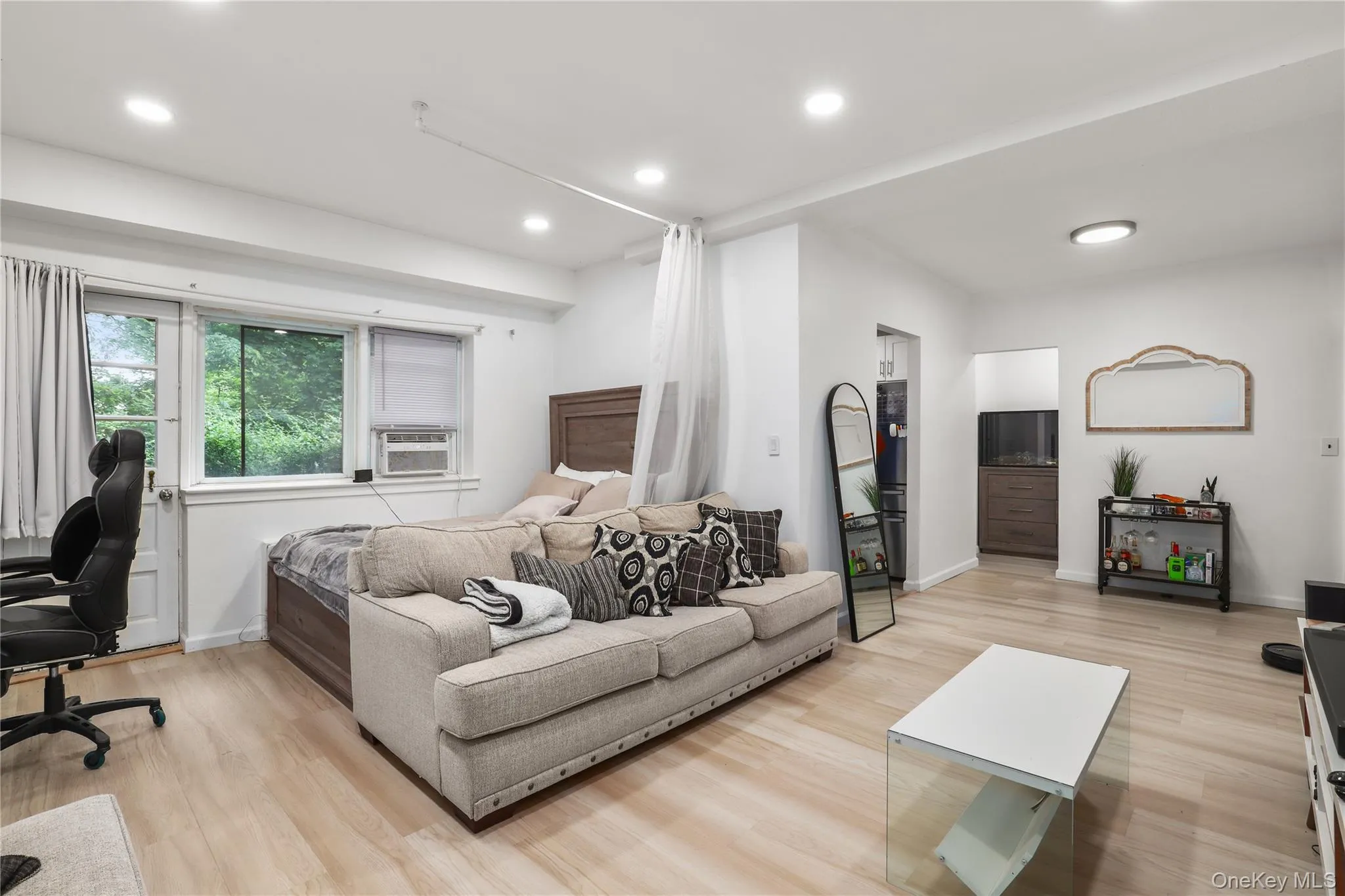 Living area with light wood finished floors, recessed lighting, cooling unit, and an office area Living area with light wood finished floors, recessed lighting, cooling unit, and an office area