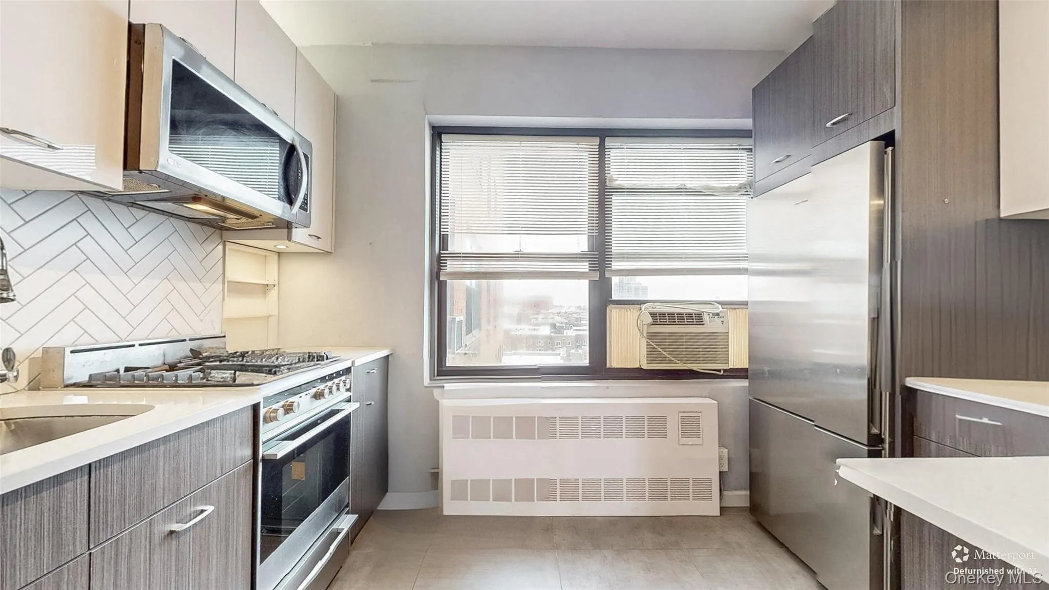 Kitchen featuring appliances with stainless steel finishes, radiator heating unit, modern cabinets, and backsplash Kitchen featuring appliances with stainless steel finishes, radiator heating unit, modern cabinets, and backsplash