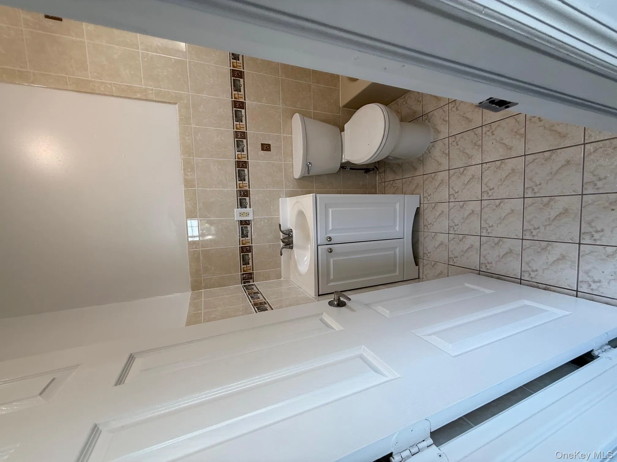 Bathroom with tile walls, vanity, a tub to relax in, and light tile patterned floors Bathroom with tile walls, vanity, a tub to relax in, and light tile patterned floors