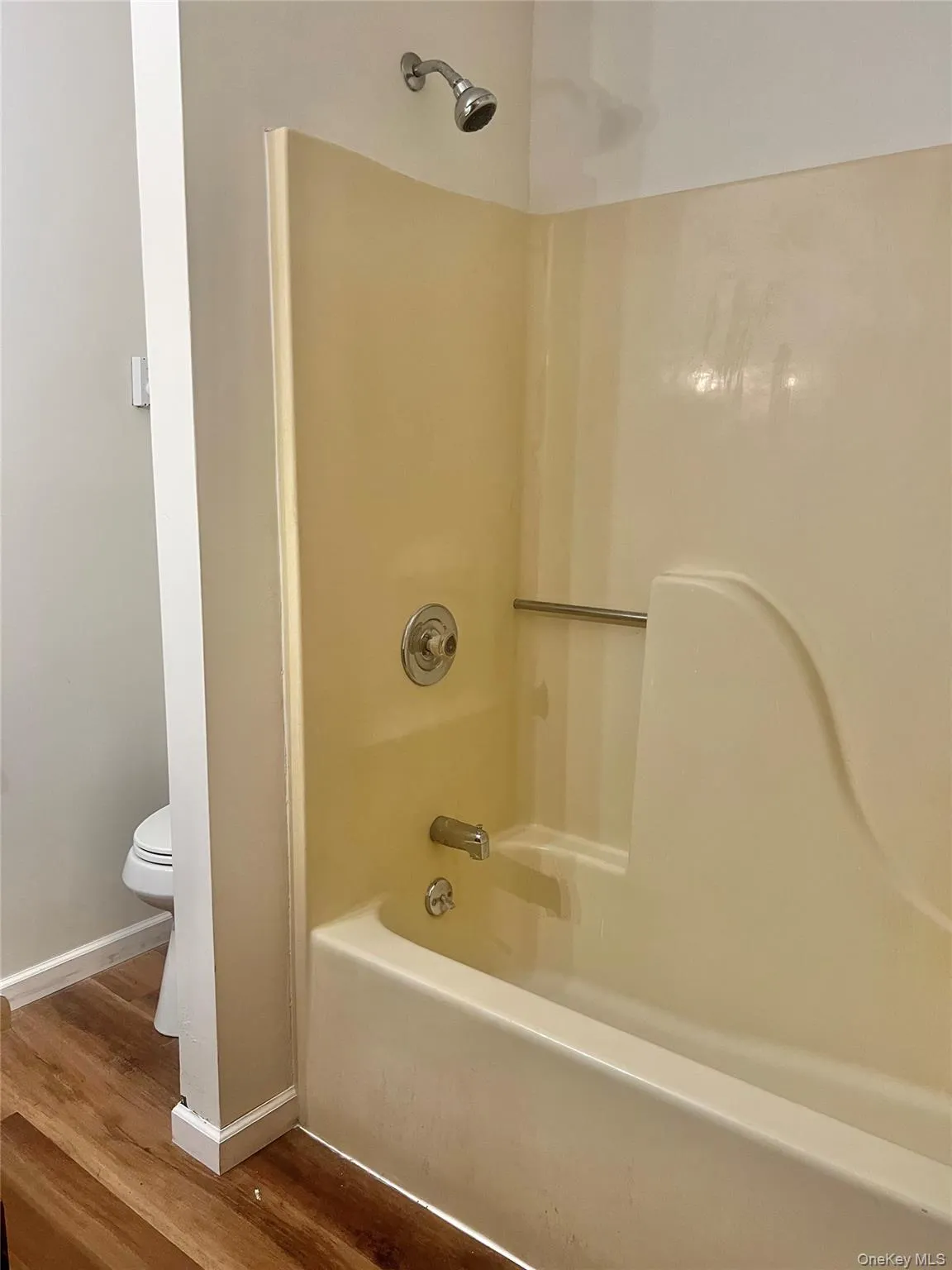 Full bath with wood finished floors and bathing tub / shower combination Full bath with wood finished floors and bathing tub / shower combination