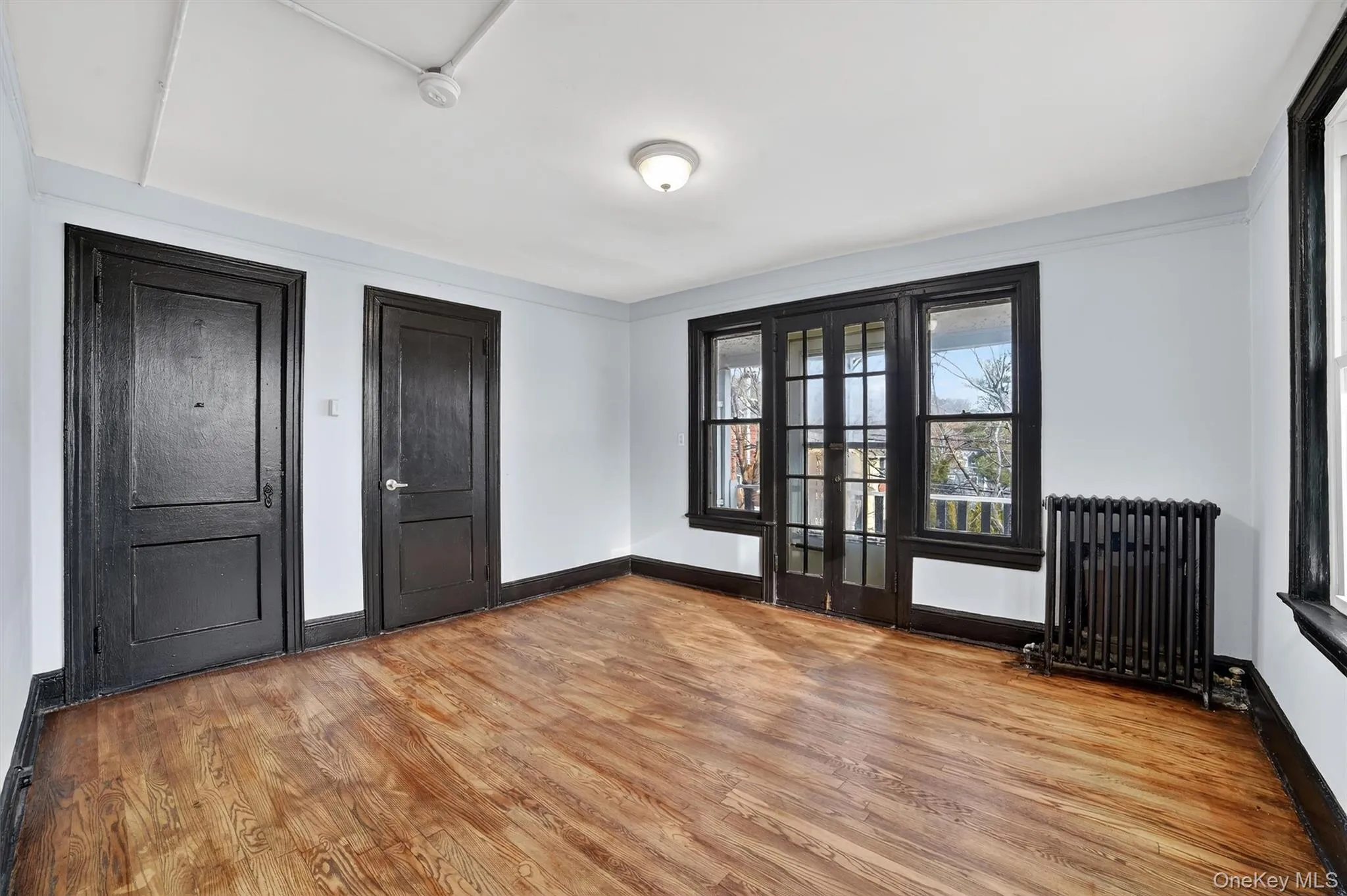 Entryway featuring radiator heating unit, light wood-style flooring, and french doors Entryway featuring radiator heating unit, light wood-style flooring, and french doors