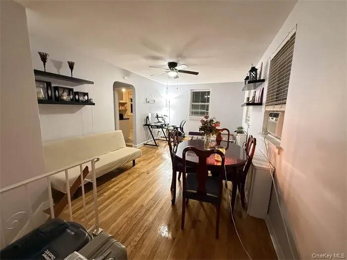 Dining area with arched walkways, light wood finished floors, and ceiling fan Dining area with arched walkways, light wood finished floors, and ceiling fan