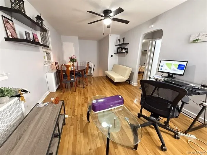Home office featuring arched walkways, light wood-style flooring, and a ceiling fan Home office featuring arched walkways, light wood-style flooring, and a ceiling fan