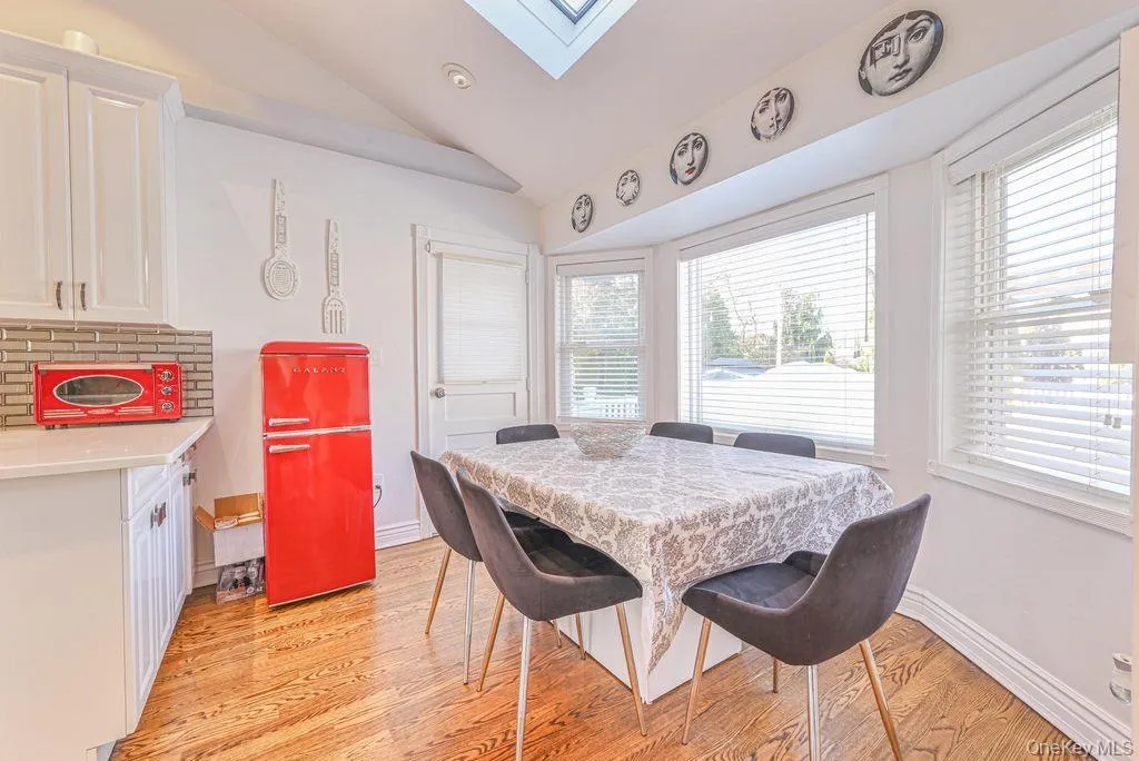 Dining area with vaulted ceiling, a skylight, and light wood finished floors Dining area with vaulted ceiling, a skylight, and light wood finished floors