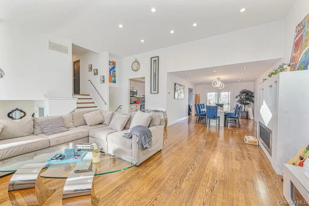 Living room with a fireplace, light wood finished floors, and recessed lighting Living room with a fireplace, light wood finished floors, and recessed lighting
