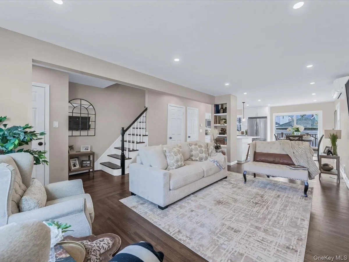 Living area featuring stairway, dark wood-style flooring, and recessed lighting Living area featuring stairway, dark wood-style flooring, and recessed lighting