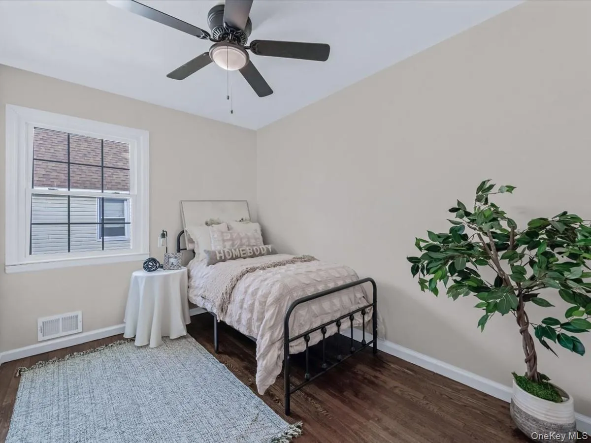 Bedroom with dark wood-type flooring and a ceiling fan Bedroom with dark wood-type flooring and a ceiling fan