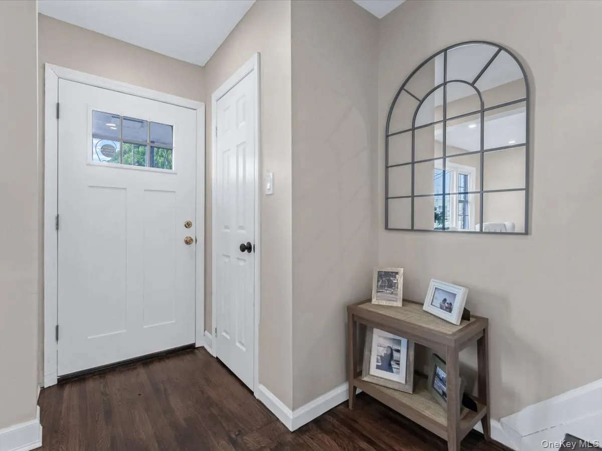 Entryway with dark wood-type flooring and baseboards Entryway with dark wood-type flooring and baseboards