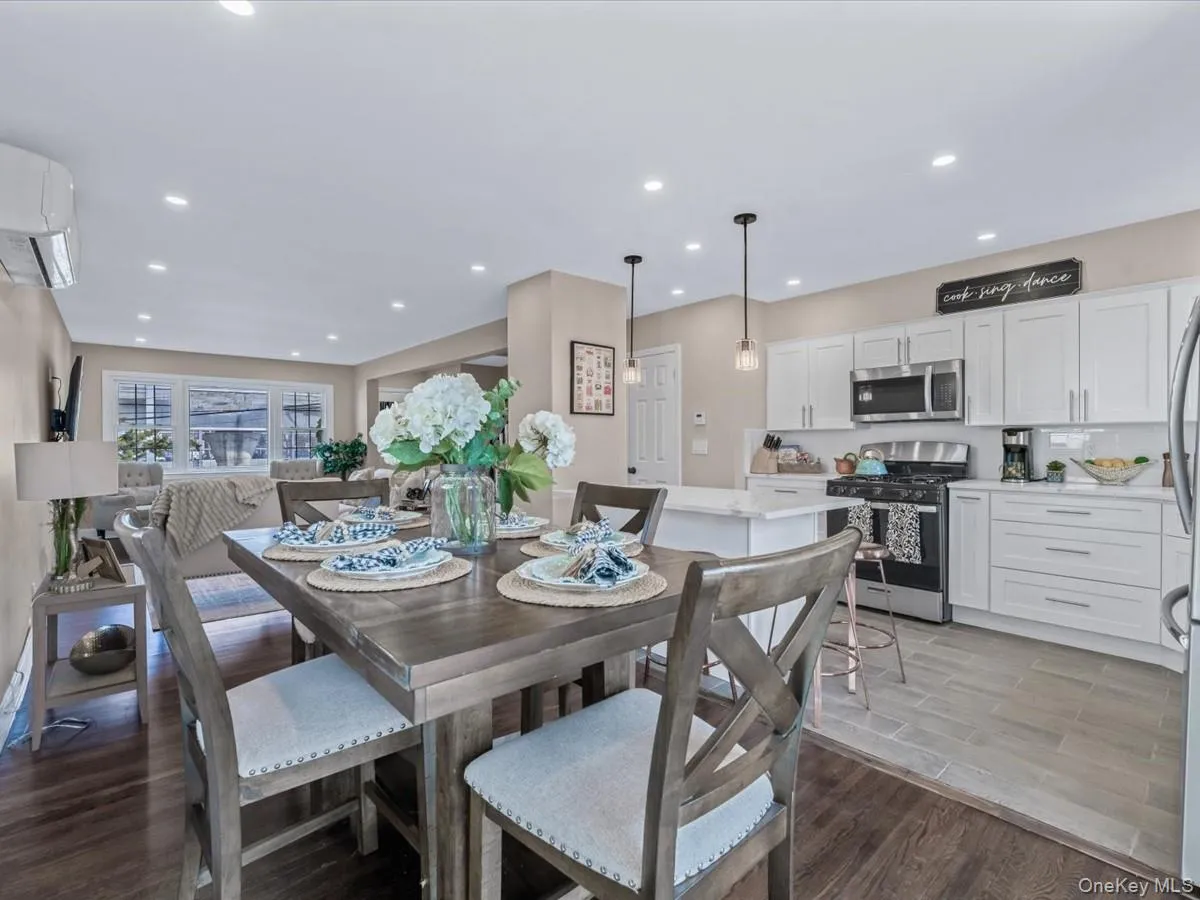Dining area featuring dark wood finished floors, recessed lighting, and a wall mounted AC Dining area featuring dark wood finished floors, recessed lighting, and a wall mounted AC