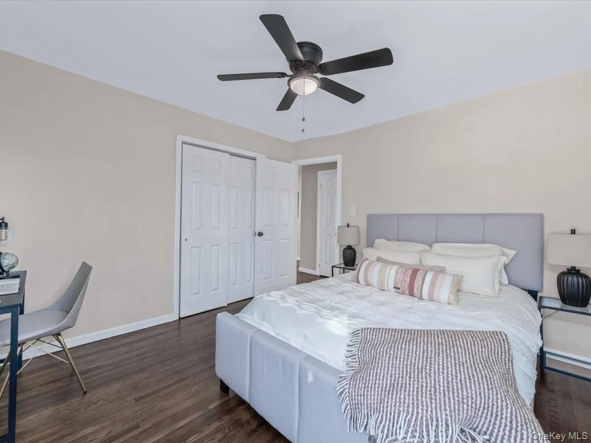 Bedroom featuring dark wood finished floors, a closet, and a ceiling fan Bedroom featuring dark wood finished floors, a closet, and a ceiling fan