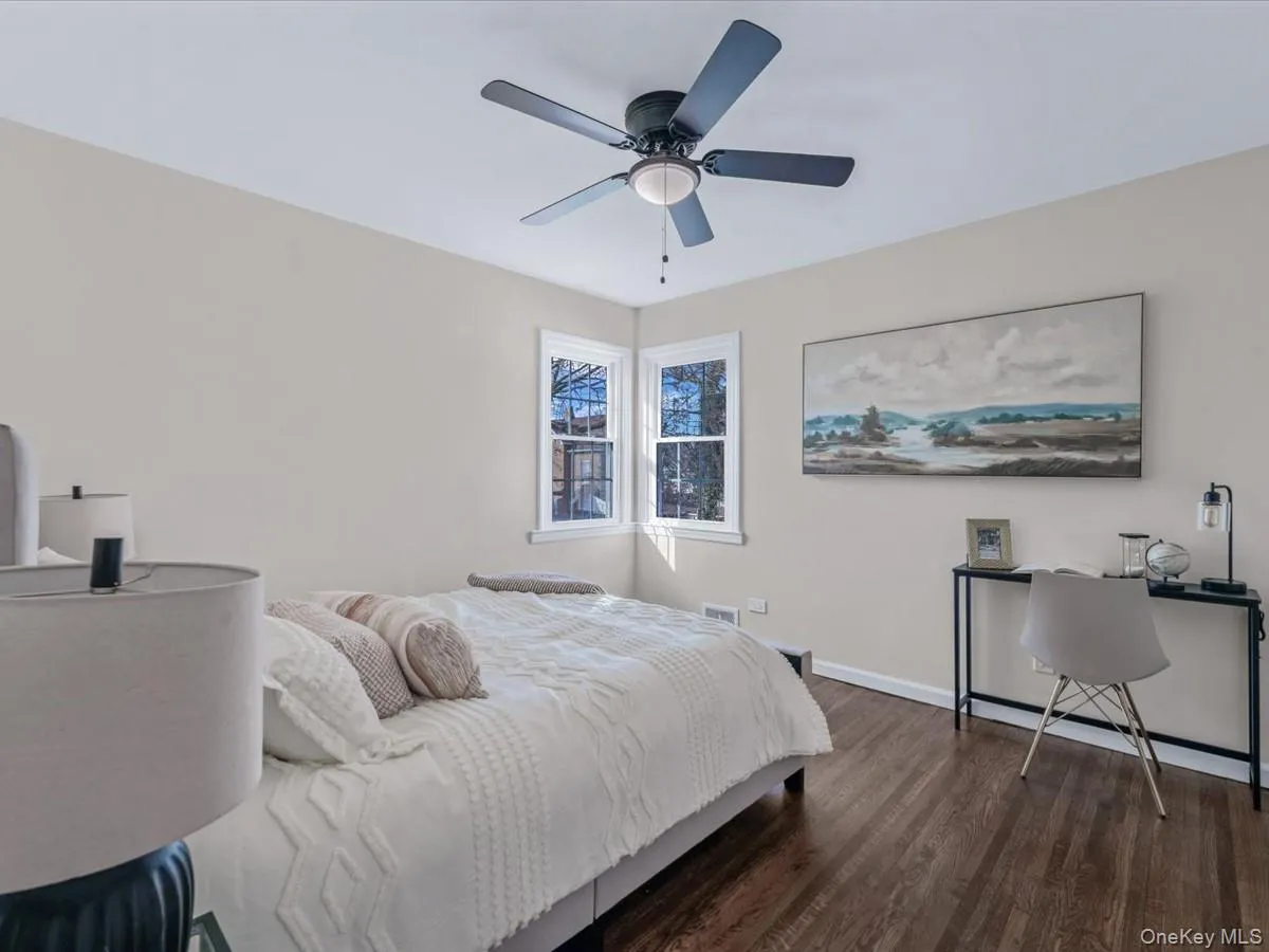 Bedroom featuring dark wood finished floors, ceiling fan, and a desk Bedroom featuring dark wood finished floors, ceiling fan, and a desk