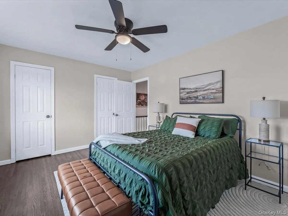 Bedroom with wood finished floors, multiple closets, and a ceiling fan Bedroom with wood finished floors, multiple closets, and a ceiling fan