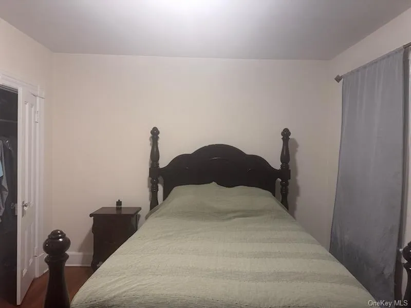 Bedroom featuring dark wood-style flooring and a closet Bedroom featuring dark wood-style flooring and a closet