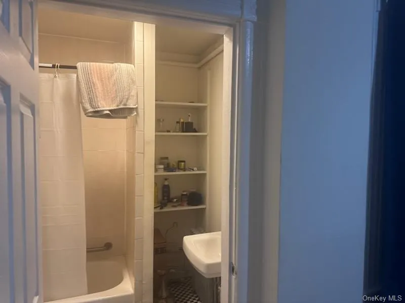 Bathroom with shower / bath combination with curtain and built in shelves Bathroom with shower / bath combination with curtain and built in shelves