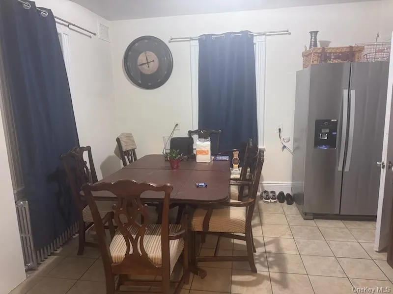 Dining area featuring light tile patterned flooring and radiator Dining area featuring light tile patterned flooring and radiator