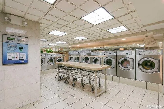 Laundry room featuring washer and dryer and a drop ceiling Laundry room featuring washer and dryer and a drop ceiling