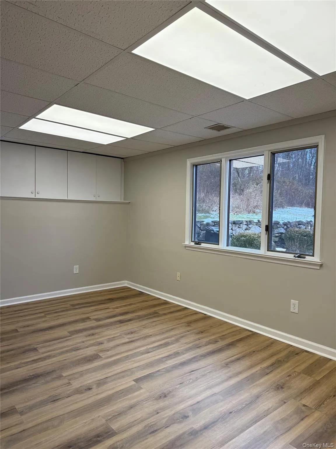 Unfurnished room featuring a paneled ceiling and wood finished floors Unfurnished room featuring a paneled ceiling and wood finished floors