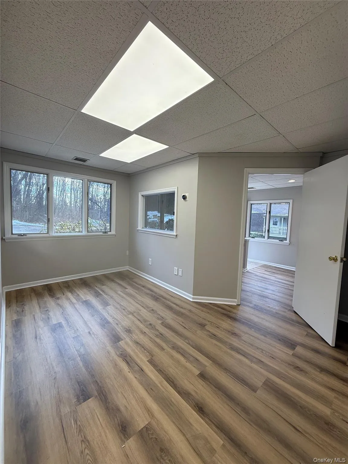 Unfurnished room with a paneled ceiling and wood finished floors Unfurnished room with a paneled ceiling and wood finished floors