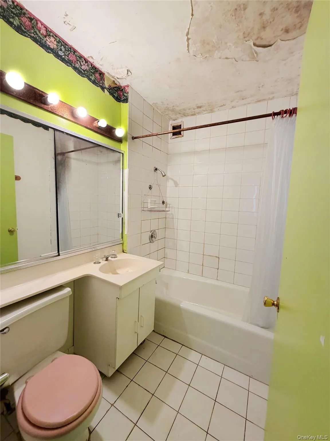 Bathroom featuring vanity, shower / bath combo with shower curtain, and light tile patterned floors Bathroom featuring vanity, shower / bath combo with shower curtain, and light tile patterned floors