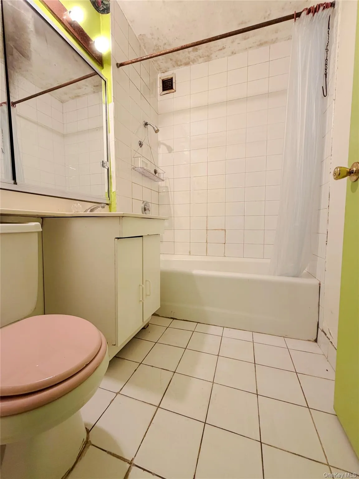 Full bathroom featuring vanity, shower / tub combo with curtain, and light tile patterned floors Full bathroom featuring vanity, shower / tub combo with curtain, and light tile patterned floors