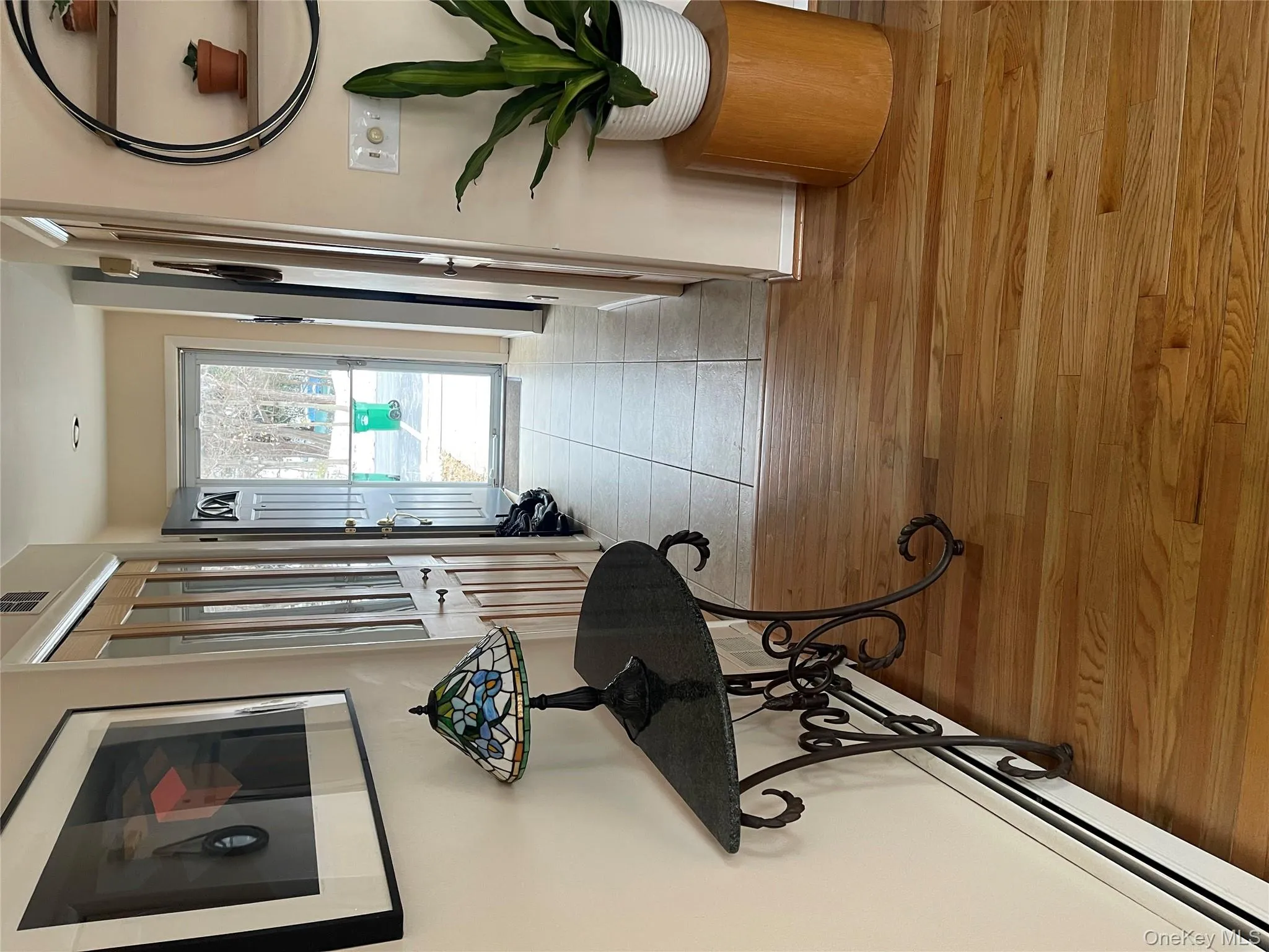 Hallway featuring baseboard heating and light wood-style floors Hallway featuring baseboard heating and light wood-style floors