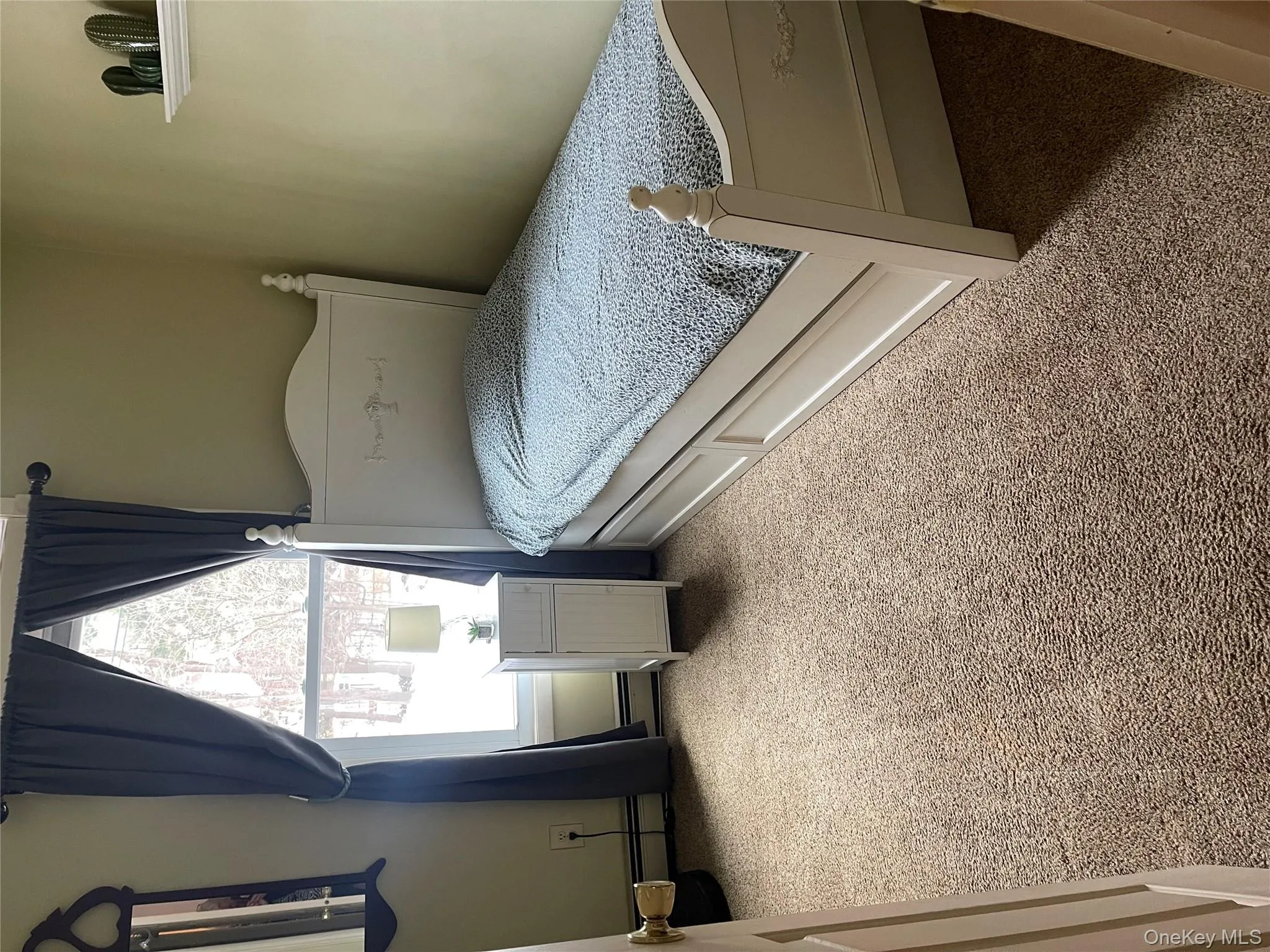 Carpeted bedroom featuring a baseboard heating unit Carpeted bedroom featuring a baseboard heating unit