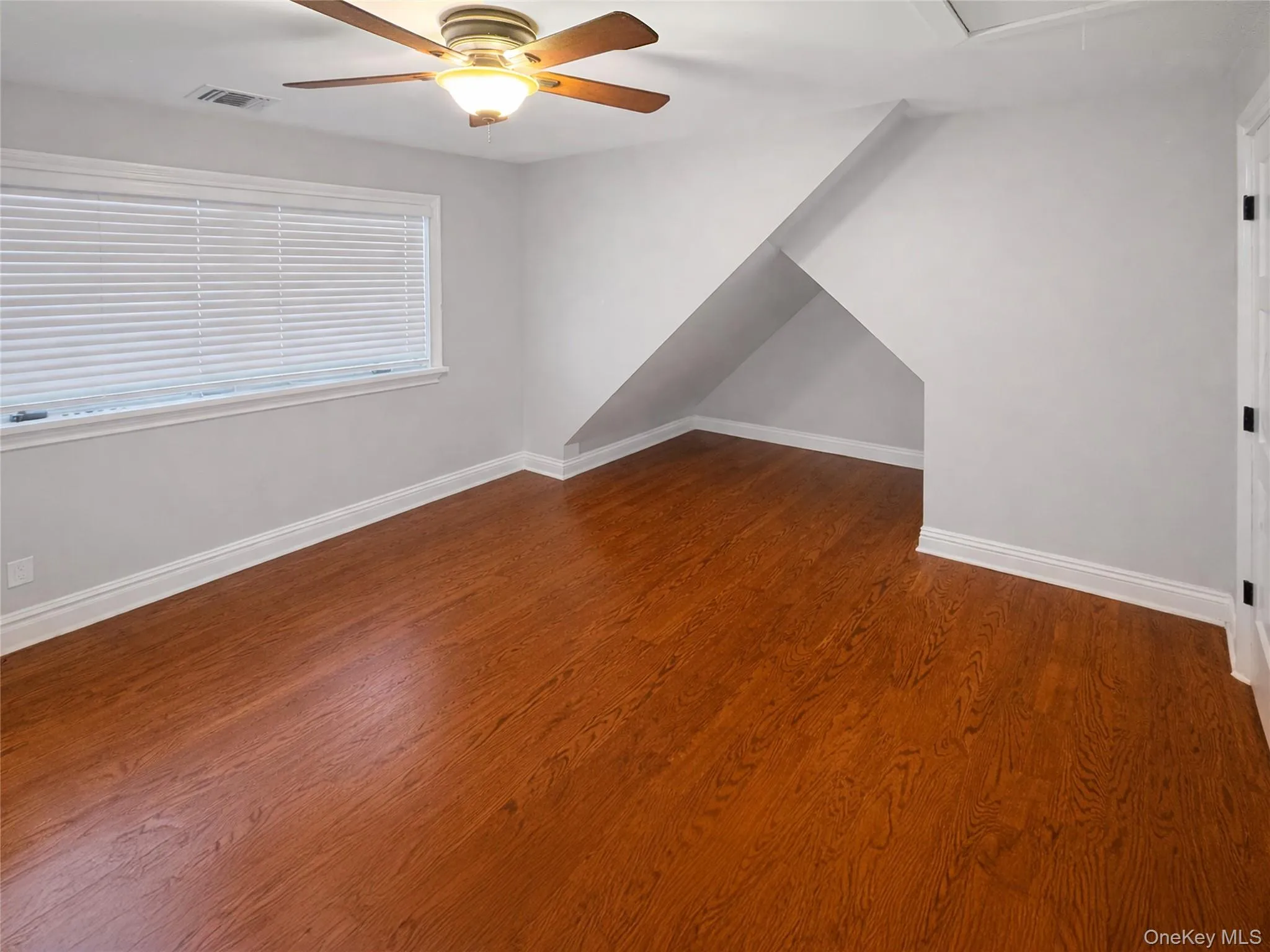 Primary Bedroom with hardwood floors, storage area, double closet, and pull down attic space Primary Bedroom with hardwood floors, storage area, double closet, and pull down attic space