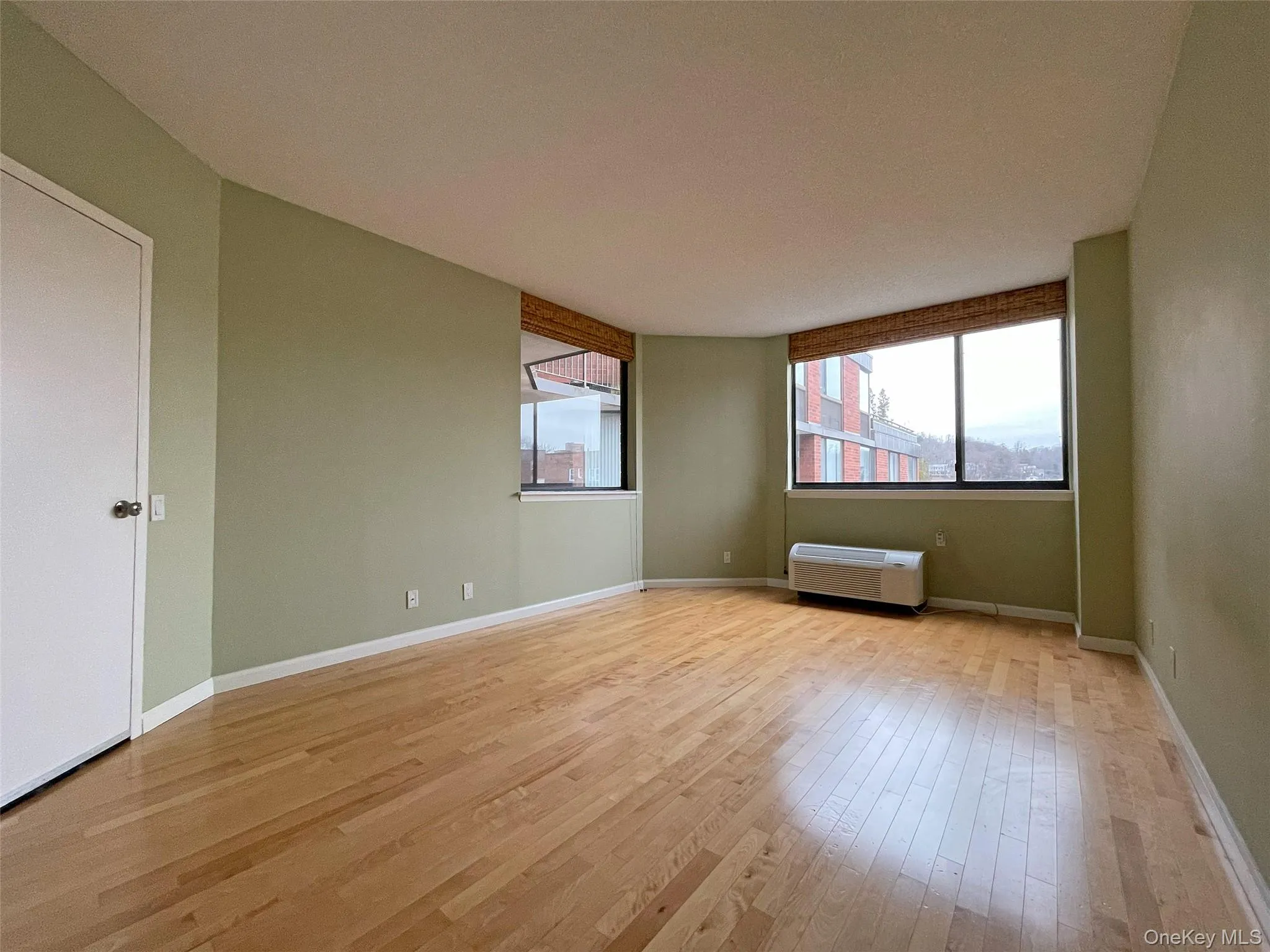 Unfurnished room with light wood finished floors and baseboards Unfurnished room with light wood finished floors and baseboards