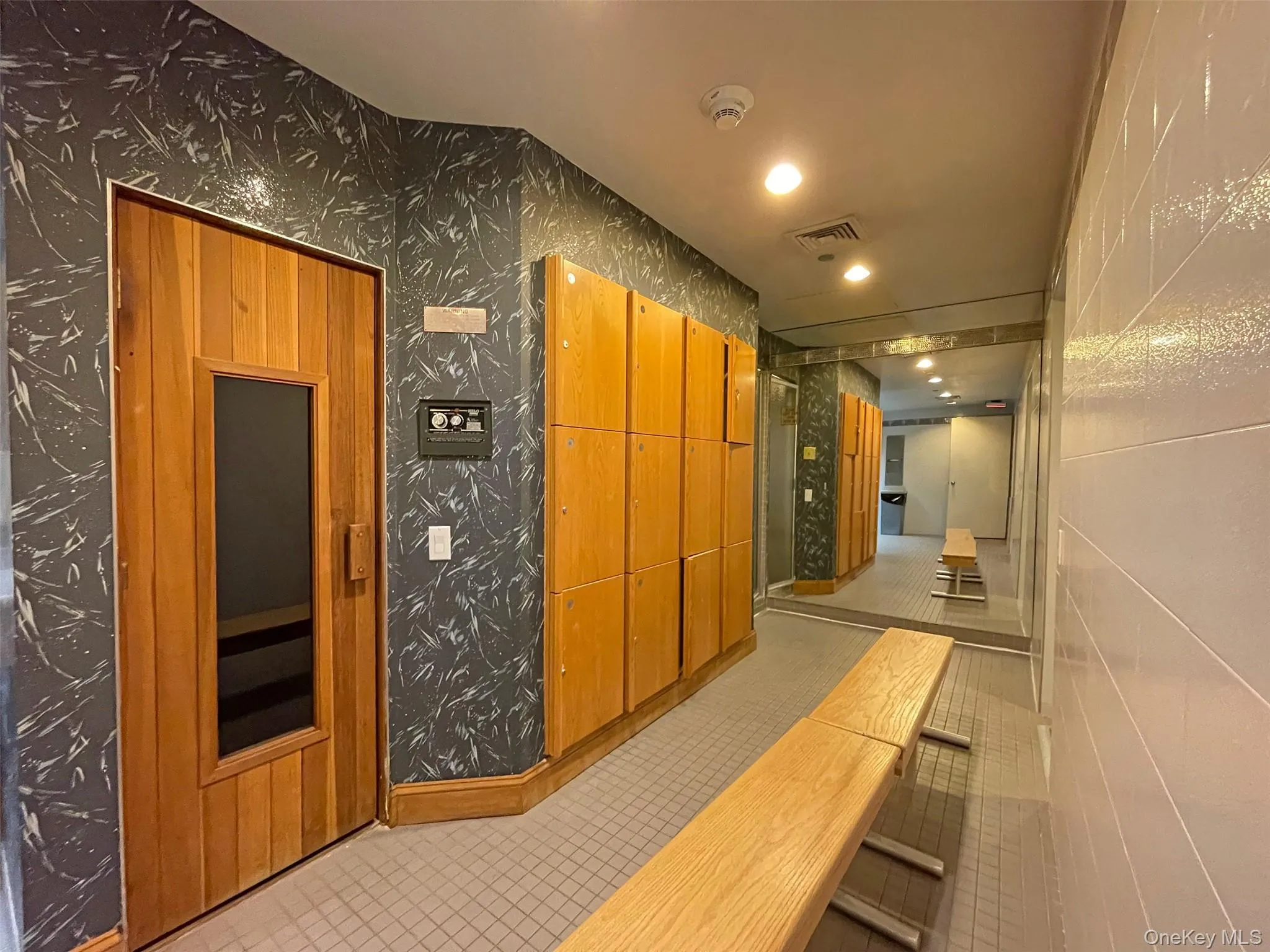 Hall with a sauna / steam room, light tile patterned flooring, and recessed lighting Hall with a sauna / steam room, light tile patterned flooring, and recessed lighting