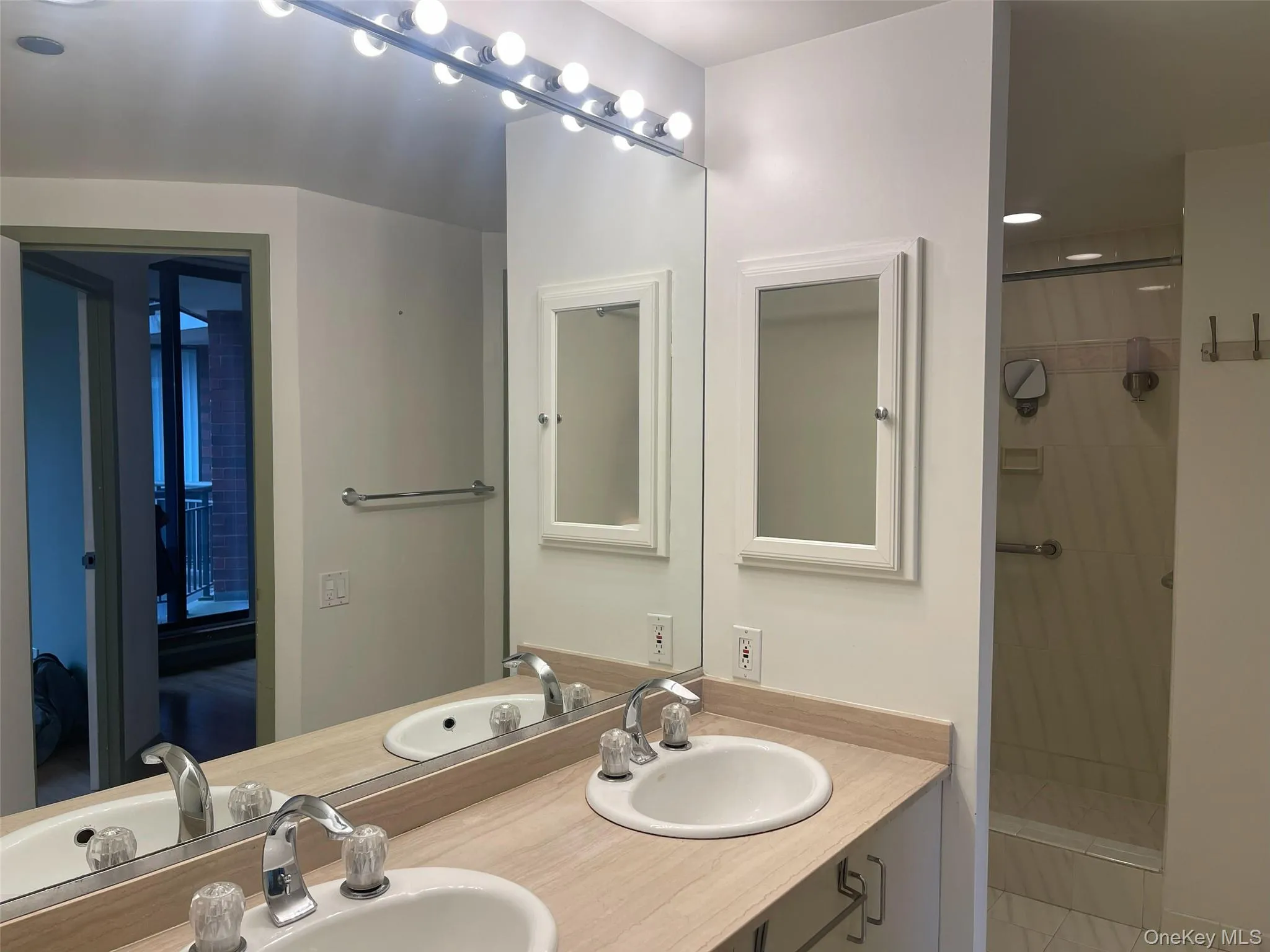 Bathroom featuring double vanity and a tile shower Bathroom featuring double vanity and a tile shower