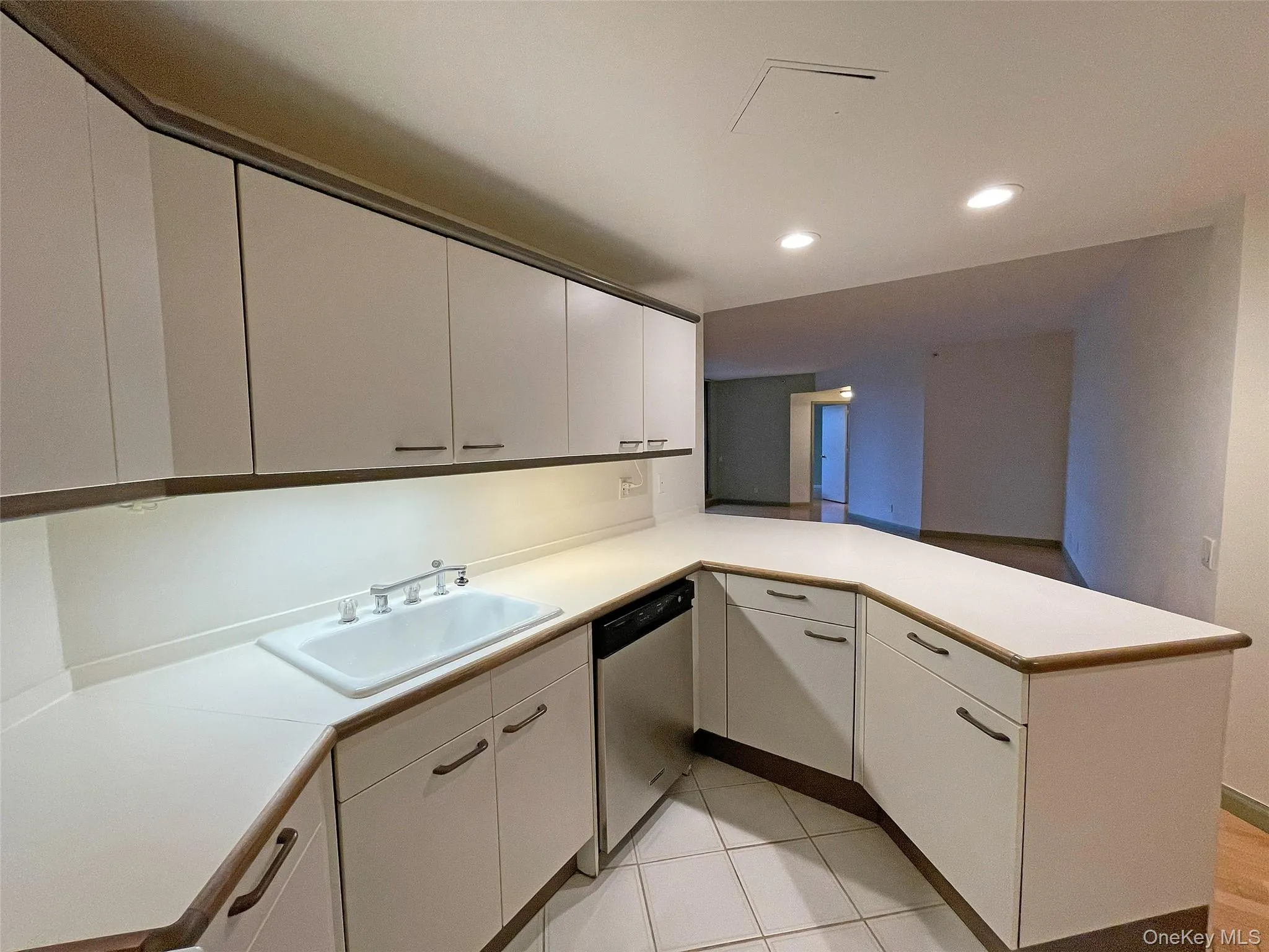 Kitchen with a peninsula, light countertops, white cabinetry, and recessed lighting Kitchen with a peninsula, light countertops, white cabinetry, and recessed lighting