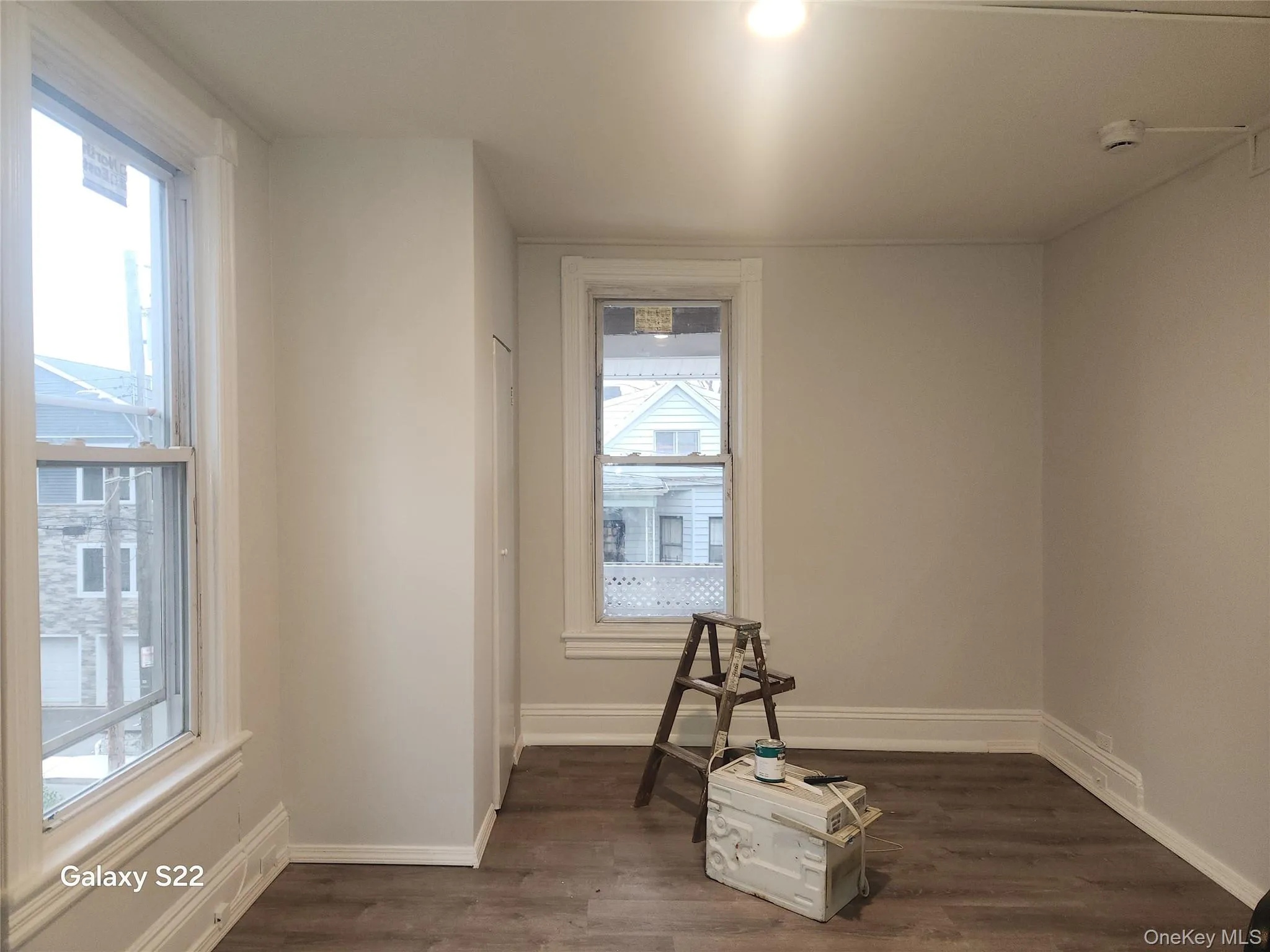 Unfurnished room featuring dark wood-type flooring and baseboards Unfurnished room featuring dark wood-type flooring and baseboards
