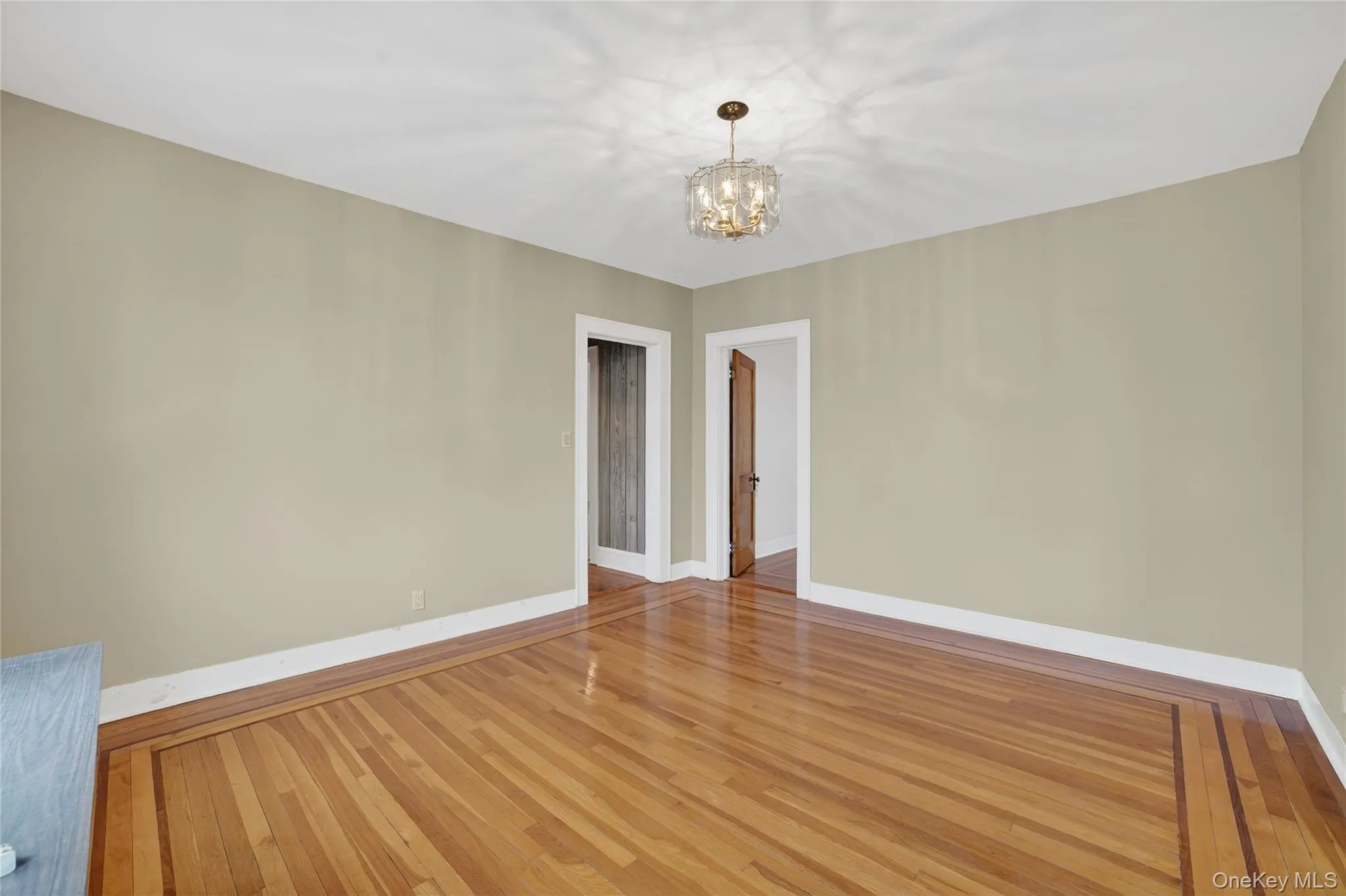 Dining room featuring wood-type flooring and a chandelier Dining room featuring wood-type flooring and a chandelier