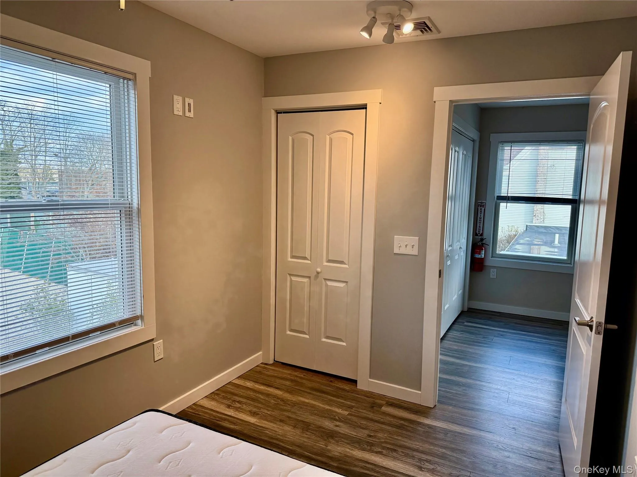 Unfurnished bedroom featuring dark wood-style flooring and a closet Unfurnished bedroom featuring dark wood-style flooring and a closet