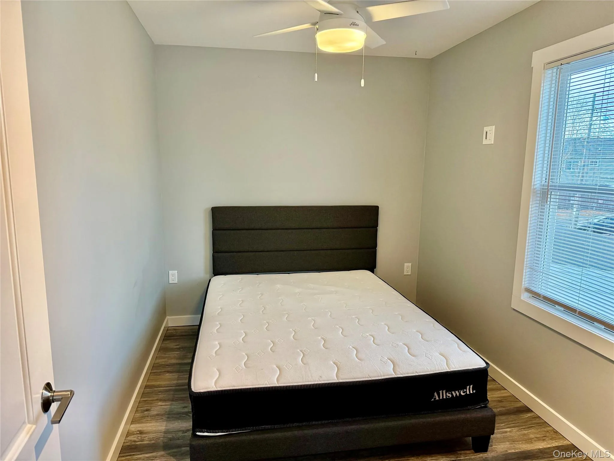 Bedroom featuring a ceiling fan and dark wood-type flooring Bedroom featuring a ceiling fan and dark wood-type flooring