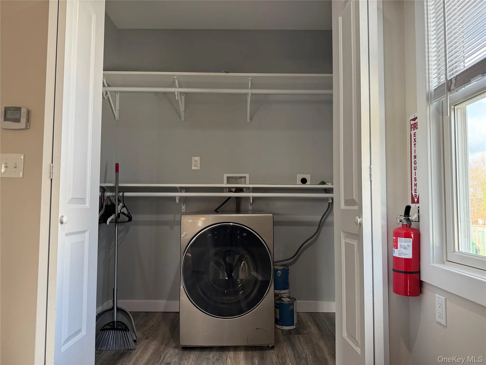 Laundry room with washer / clothes dryer and dark wood-style floors Laundry room with washer / clothes dryer and dark wood-style floors