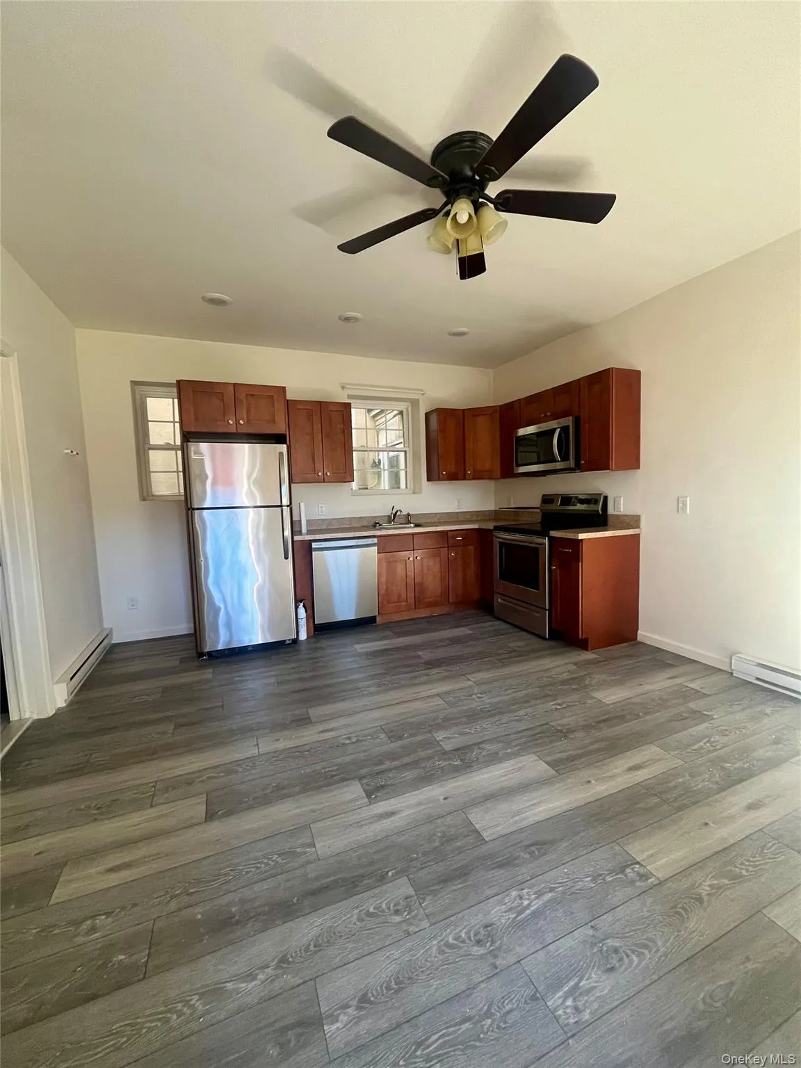 Kitchen featuring appliances with stainless steel finishes, baseboard heating, light countertops, and a baseboard heating unit Kitchen featuring appliances with stainless steel finishes, baseboard heating, light countertops, and a baseboard heating unit