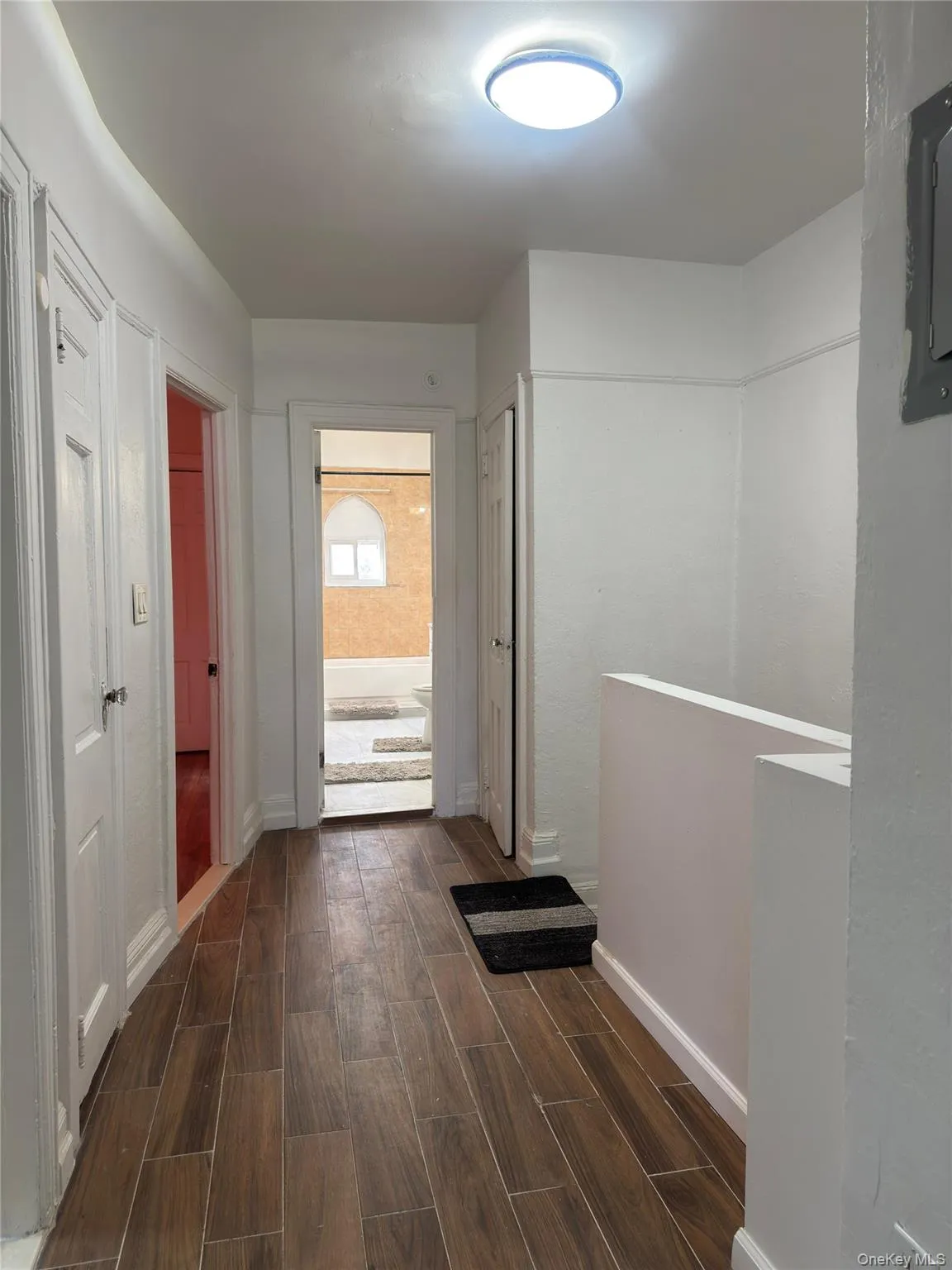 Hall featuring wood finish floors and an upstairs landing Hall featuring wood finish floors and an upstairs landing