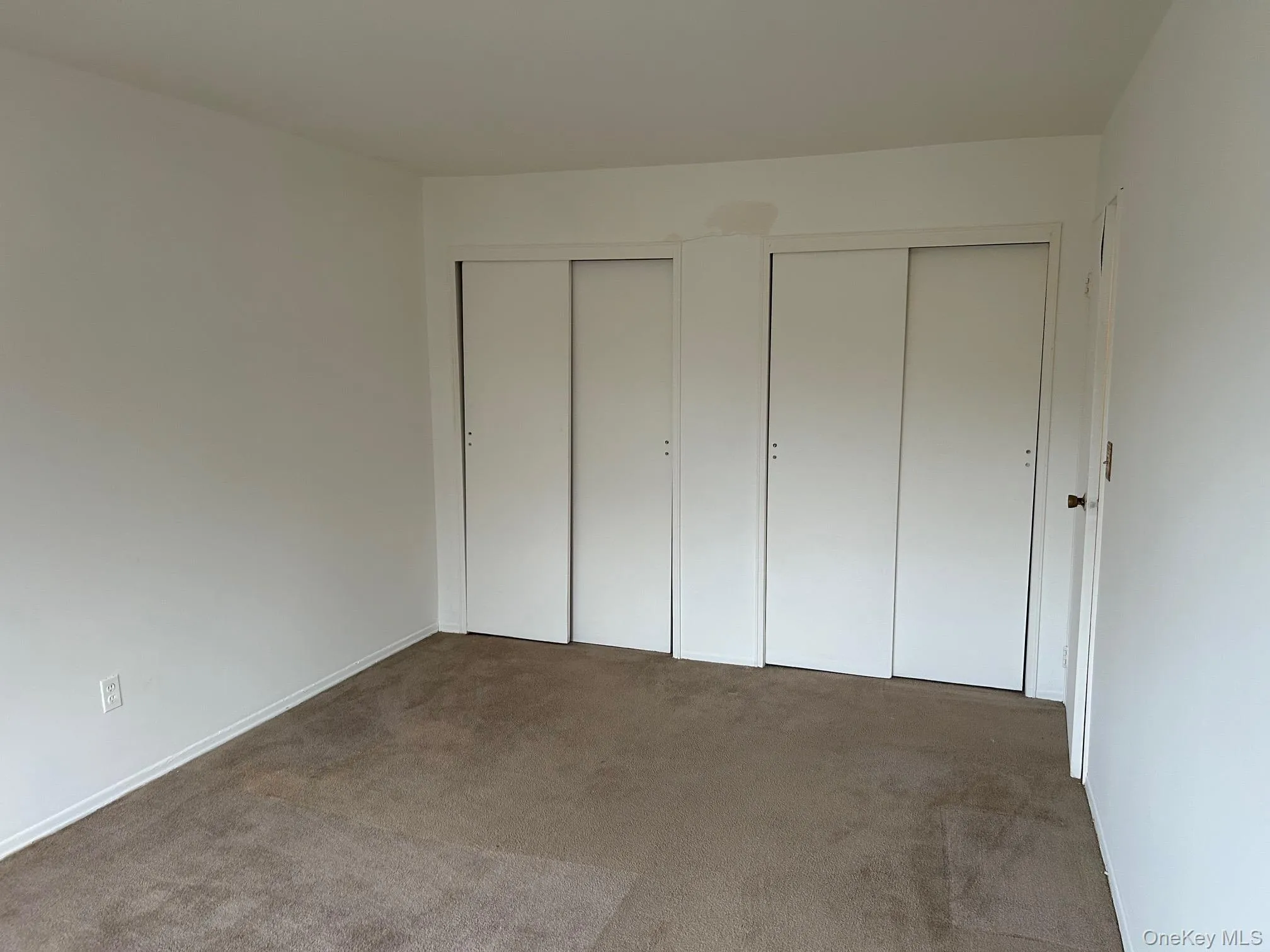 Unfurnished bedroom with two closets and carpet Unfurnished bedroom with two closets and carpet