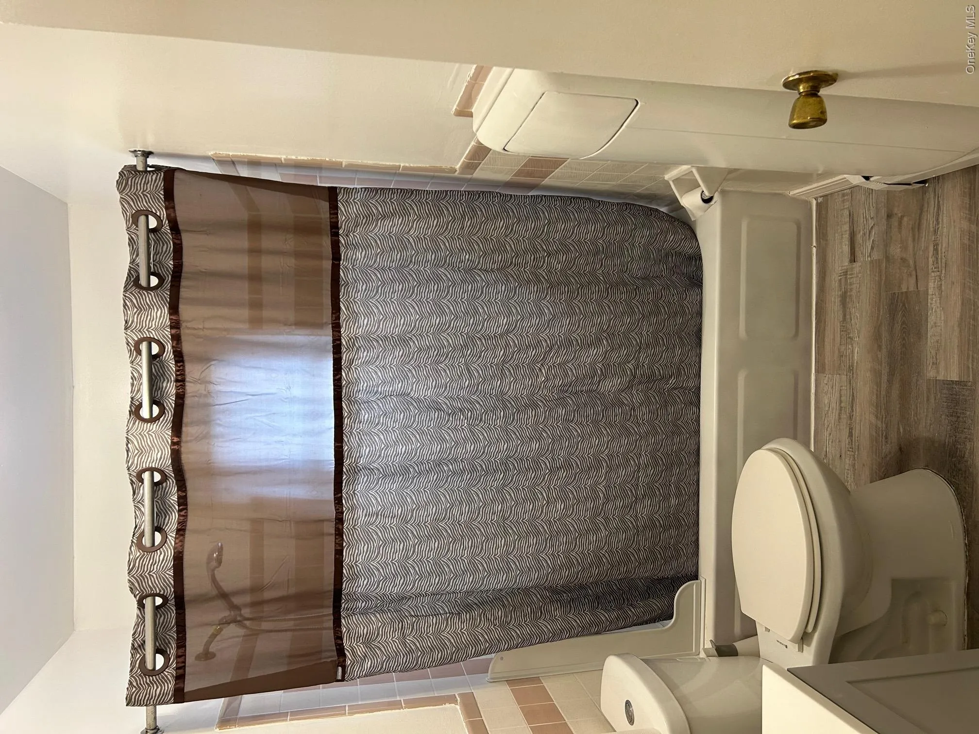 Bathroom featuring dark wood-style floors, shower / tub combo, and vanity Bathroom featuring dark wood-style floors, shower / tub combo, and vanity